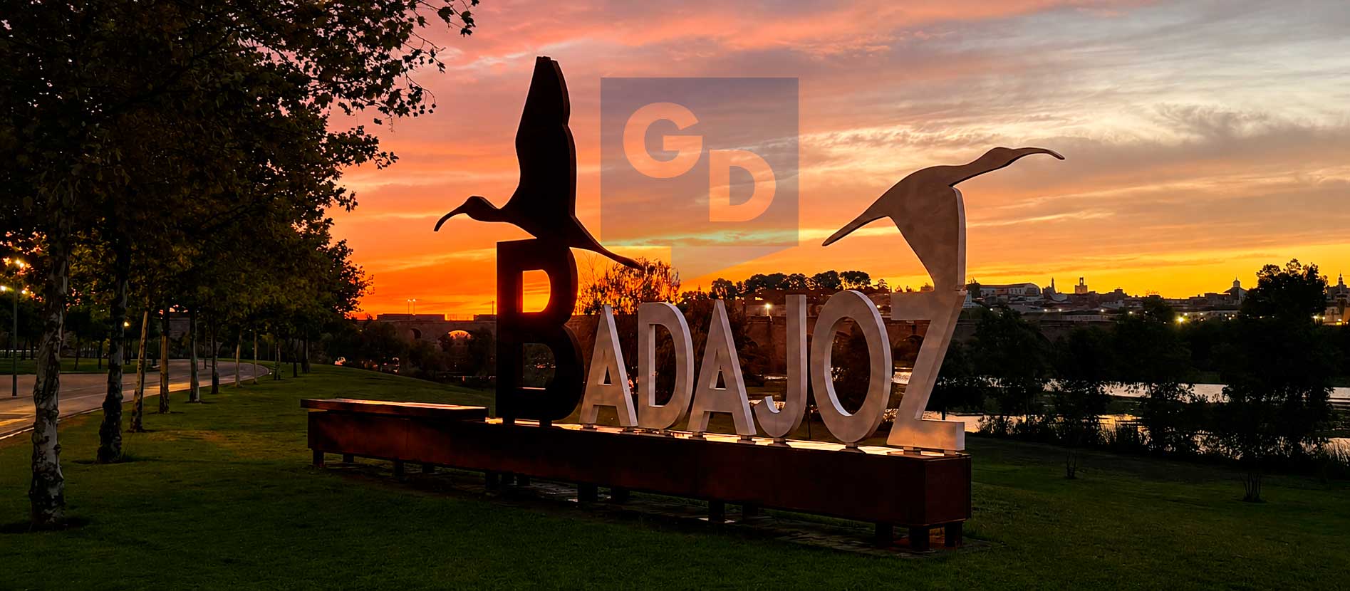 Escultura con el nombre de Badajoz al atardecer junto al río Guadiana